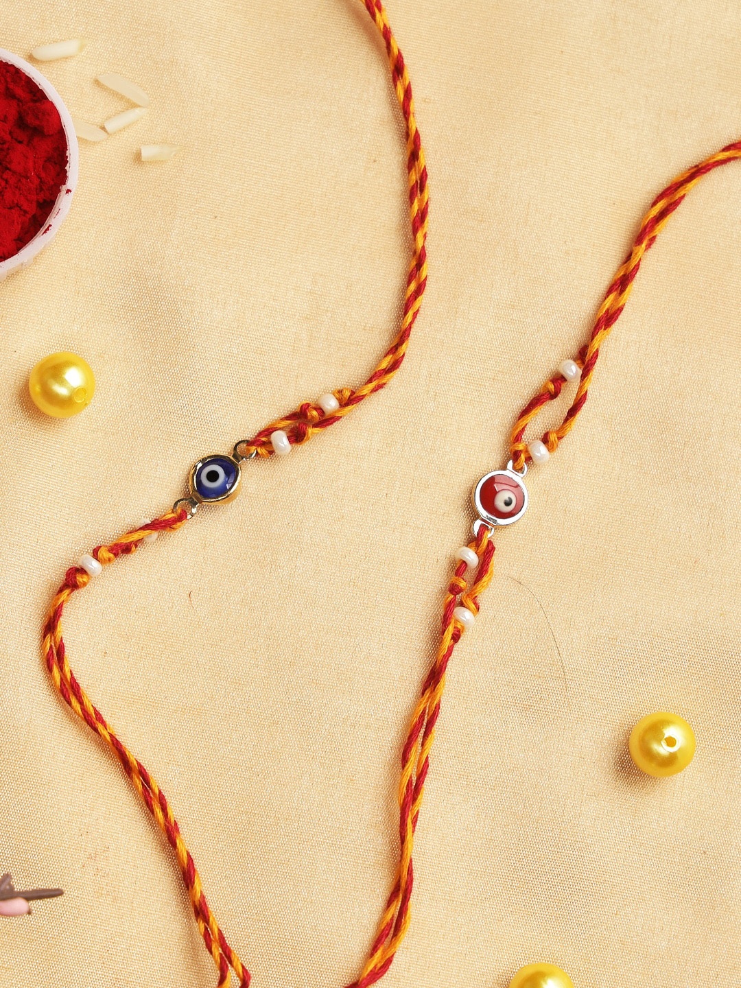 

Aapno Rajasthan Set Of 2 Red & Blue Evil Eye Rakhi With Roli Chawal & Card