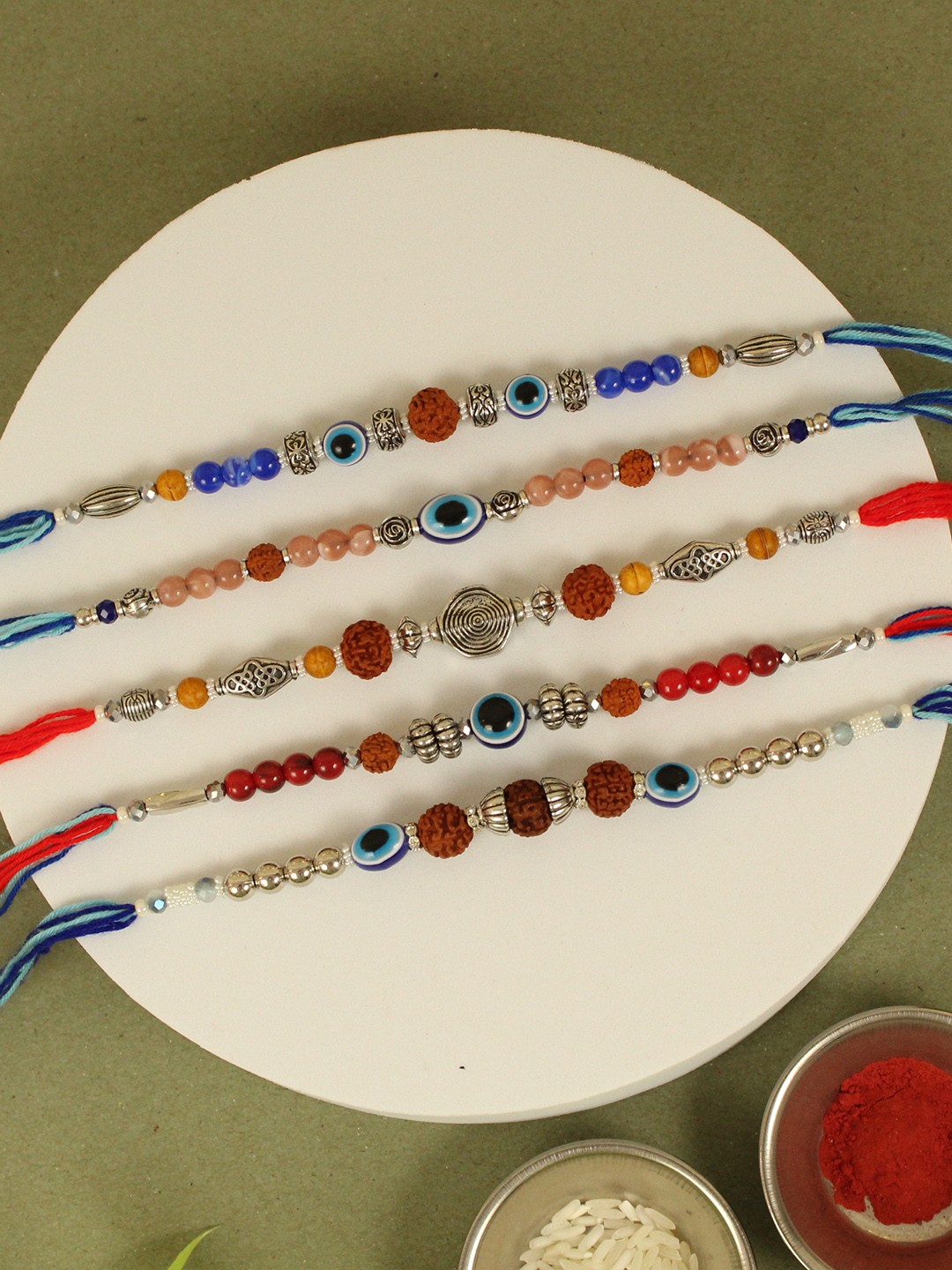 

TIED RIBBONS Set of 5 Rudraksh Pearl Rakhi with Card & Roli Chawal, Multi