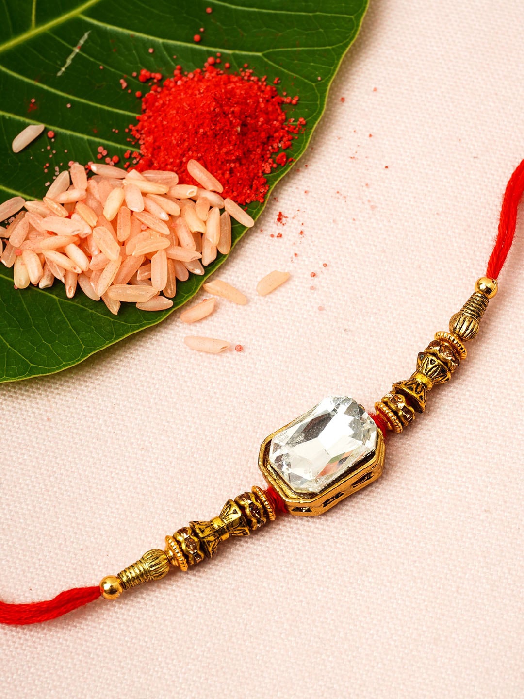 

Urmika Men Gold-Toned & Maroon Beaded & White Stone Studded Rakhi