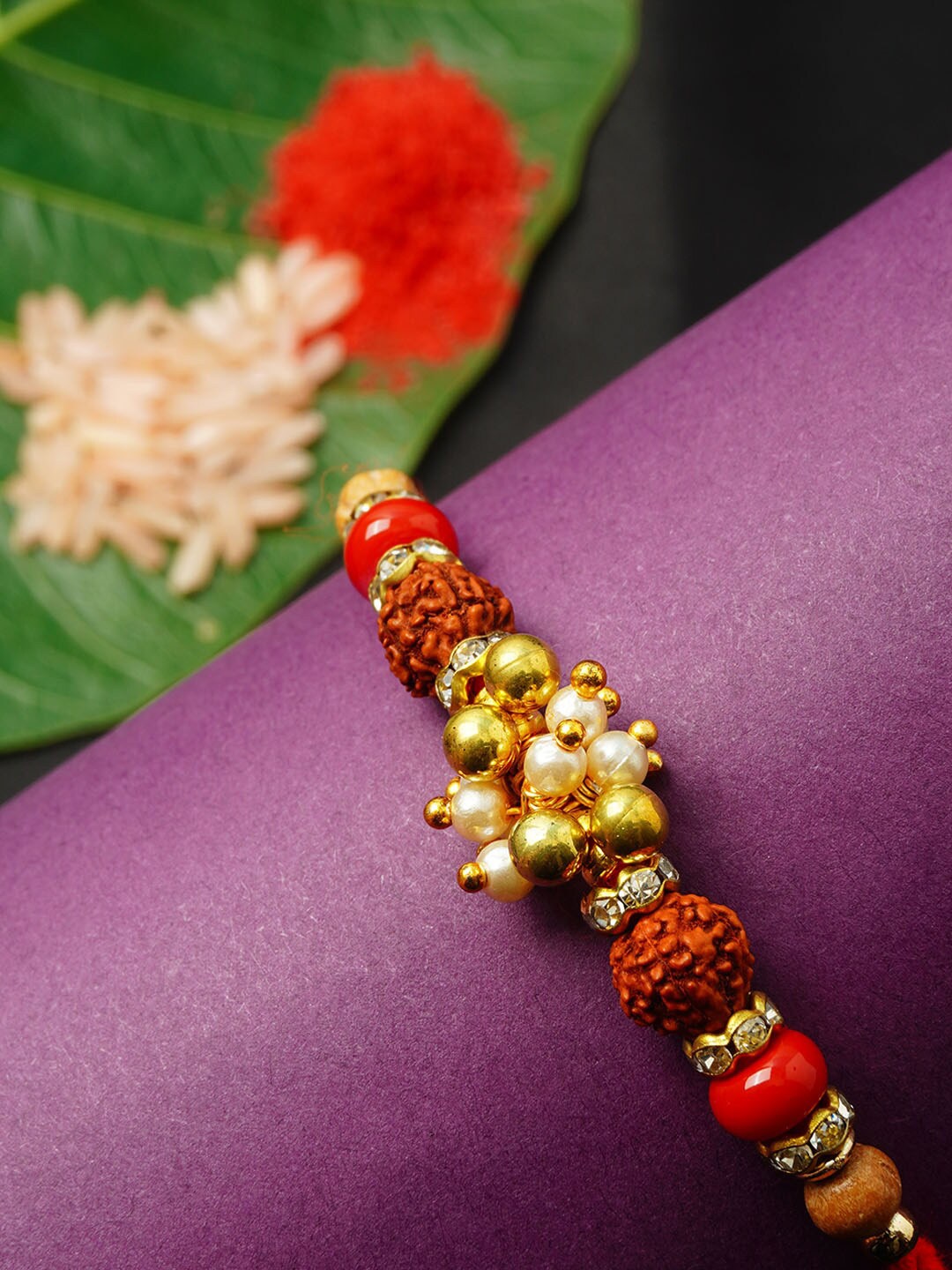 

Urmika Men Red & Gold-Toned Stone-Studded & Beaded Rakhi With Roli Chawal