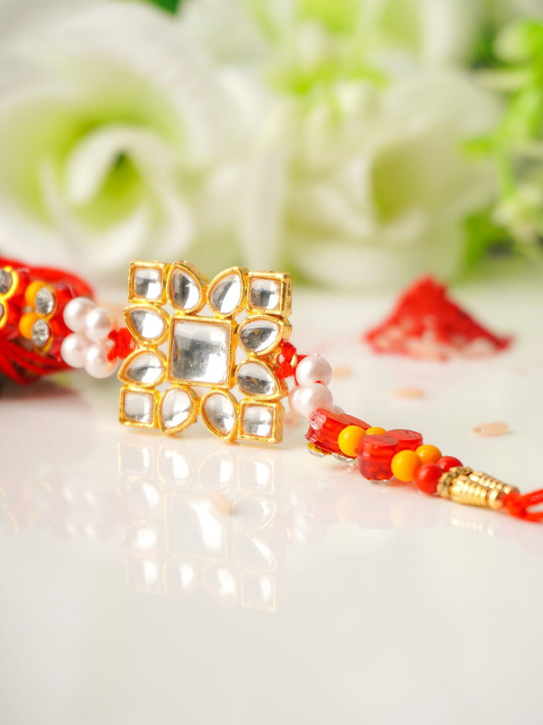 

Urmika Men Red & Gold-Coloured Kundan-Studded Rakhi With Roli Chawal