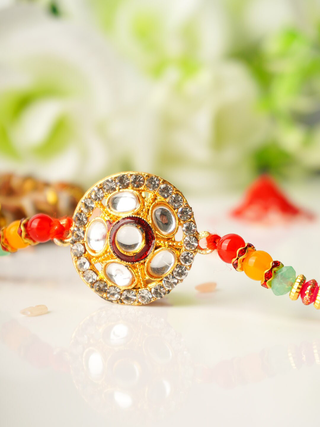 

Urmika Men Gold-Toned & White Crystal Studded & Beaded Rakhi & Roli Chawal