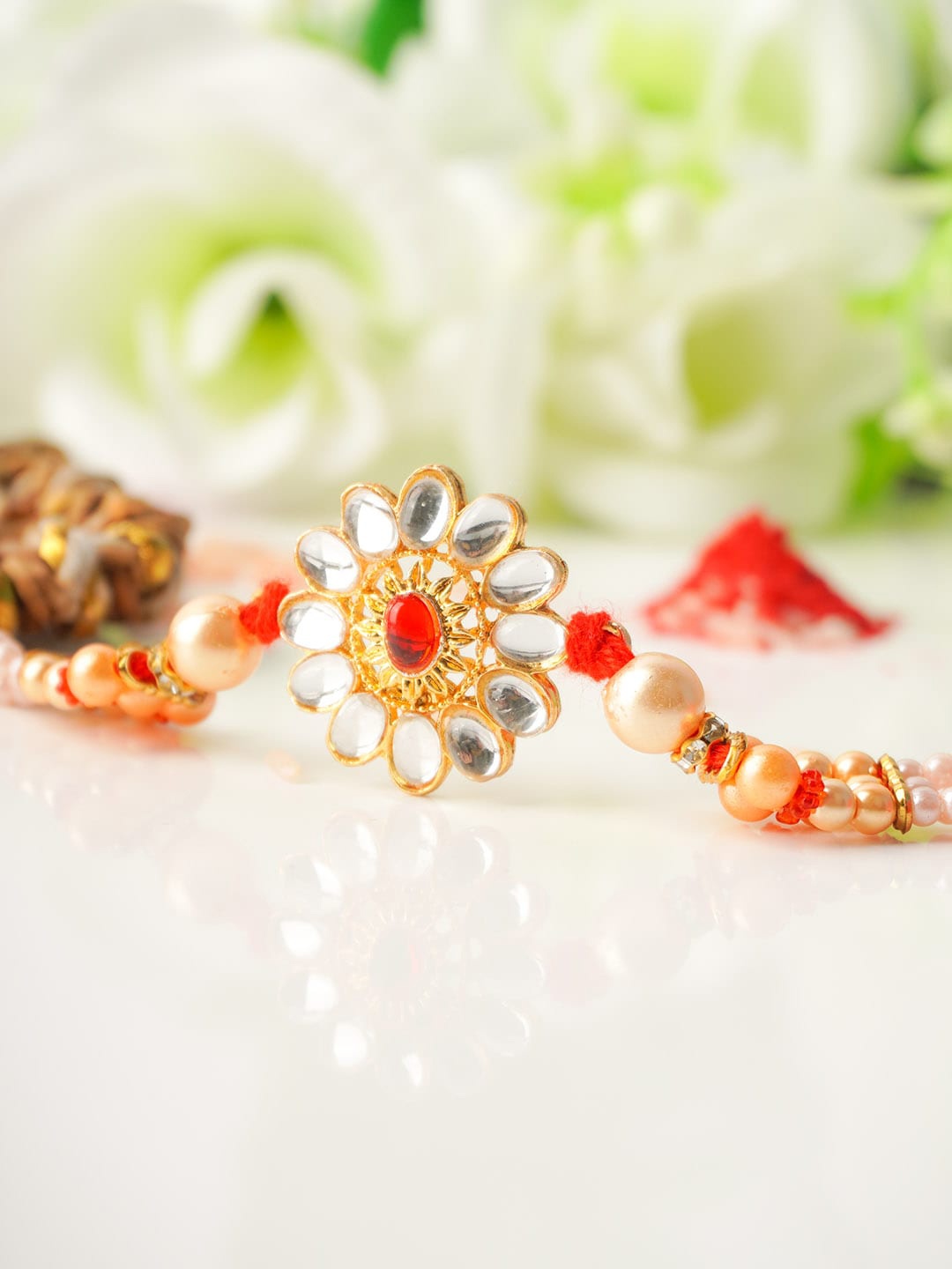 

Urmika Men Gold Toned & Red Crystal Flower Beaded Rakhi