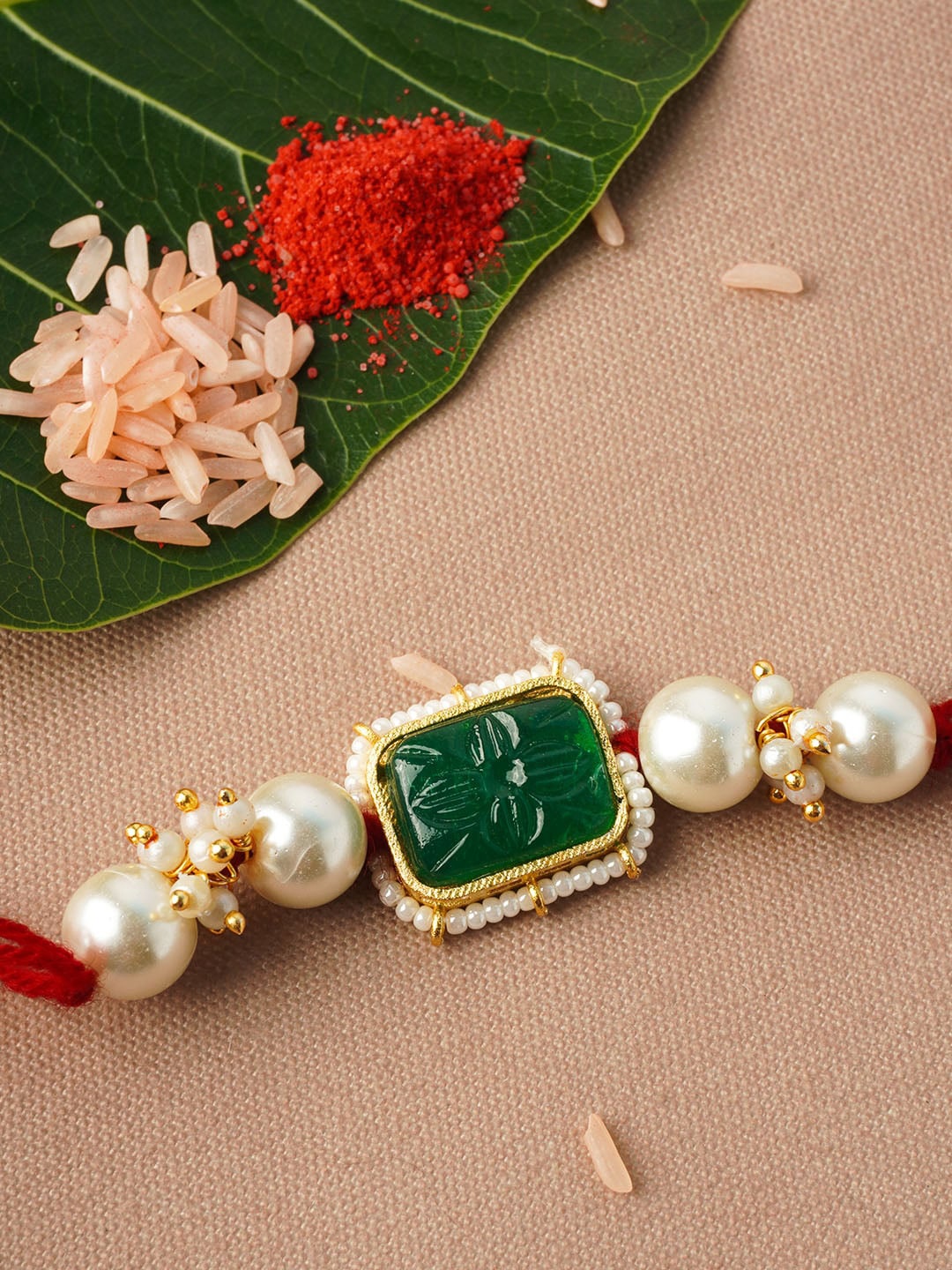

Urmika Men Gold-Toned Green Crystal Studded & Pearl Rakhi With Roli Chawal