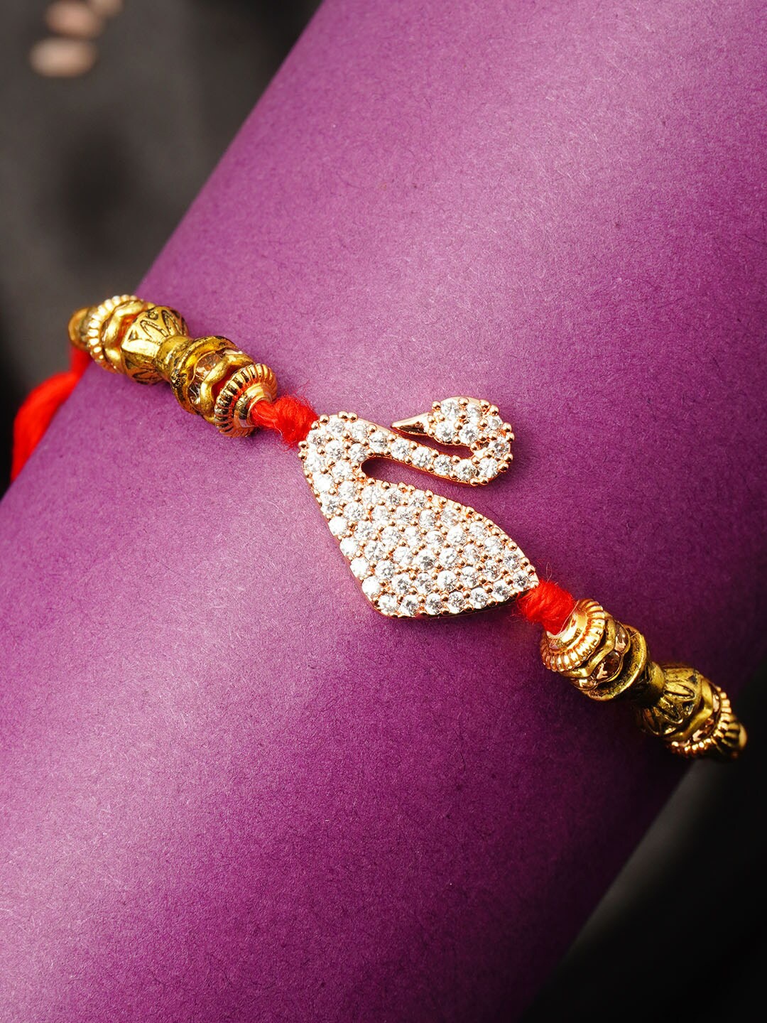 

Urmika Men Gold-Coloured & Red Stone-Studded & Beaded Rakhi With Roli Chawal