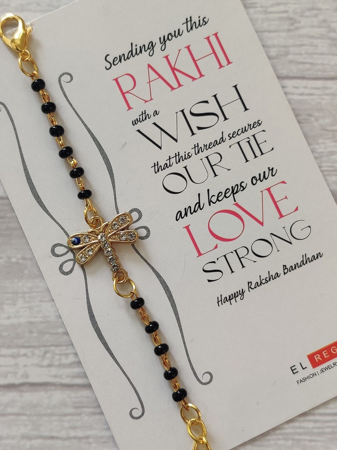 

EL REGALO Kids Gold-Toned Nazaria Rakhi Combo with Greeting Card & Roli Chawal Shagun