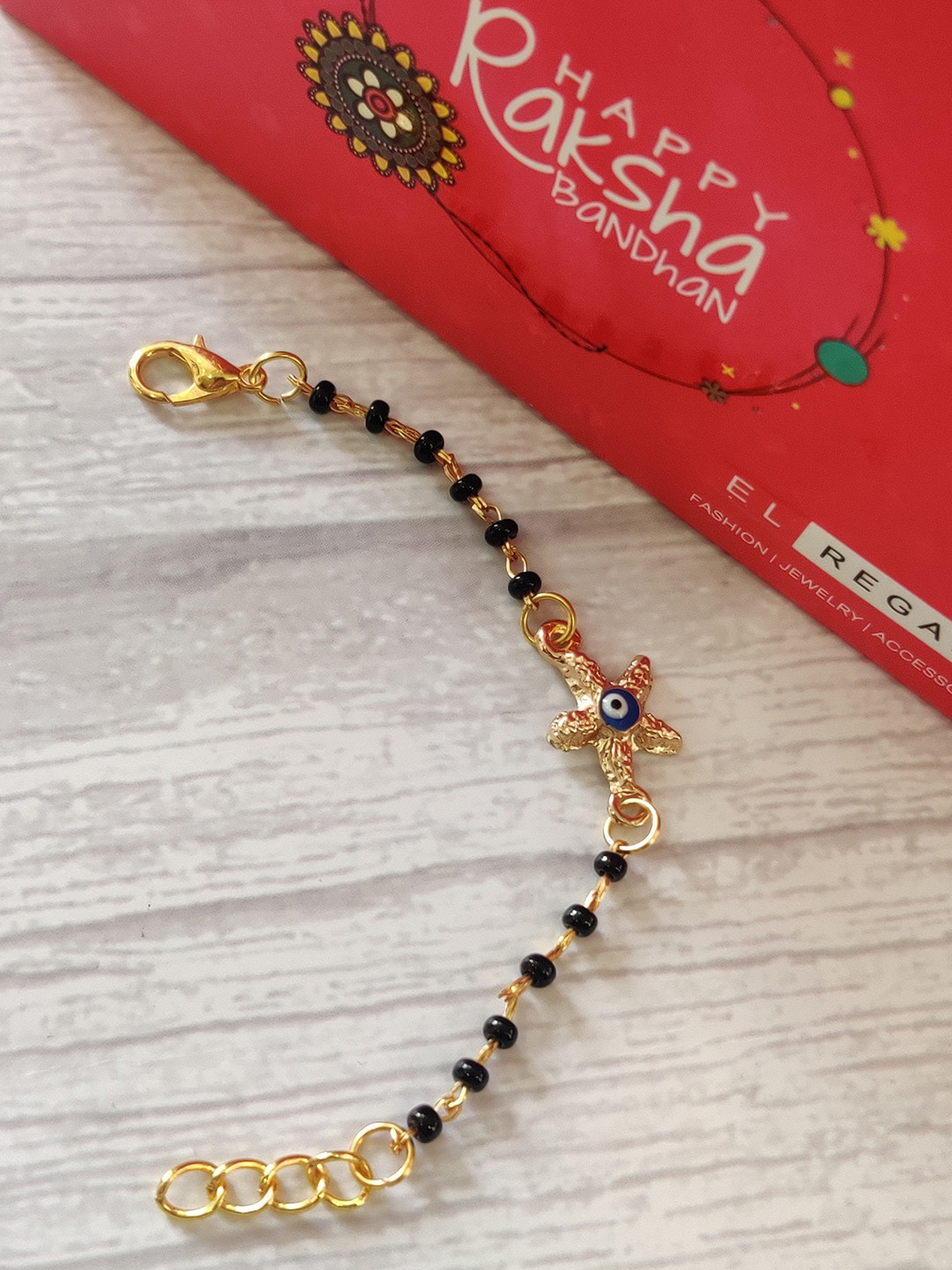 

EL REGALO Kids Black Nazaria Rakhi Combo with Greeting Card & Roli Chawal Shagun