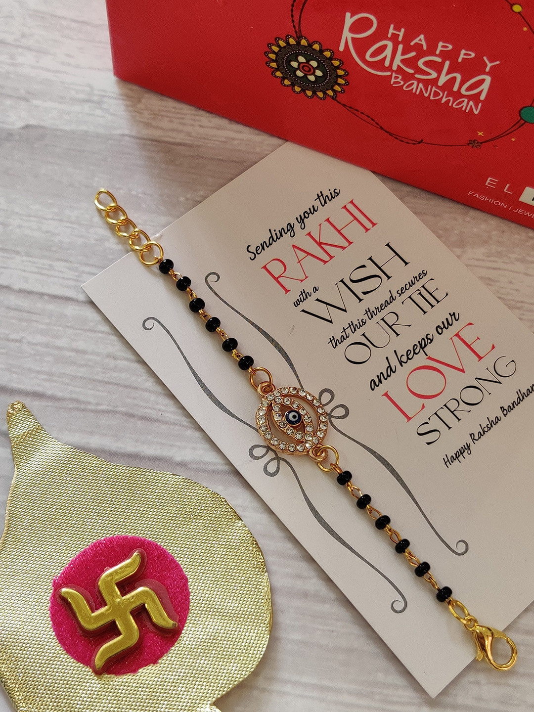 

EL REGALO Kids Gold-Toned Nazaria Rakhi Combo with Greeting Card & Roli Chawal Shagun