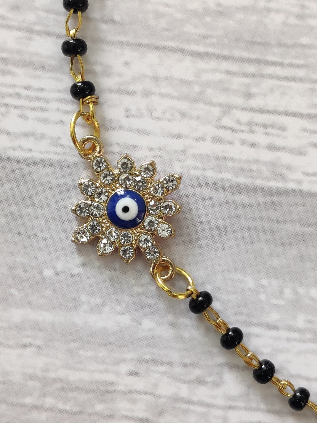 

EL REGALO Kids Gold-Toned Nazaria Rakhi Combo with Greeting Card & Roli Chawal Shagun