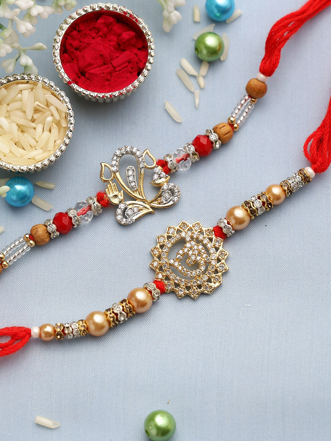 

Aapno Rajasthan Om and Ganeshi Ji Rakhi in Diamond set of 2, Red