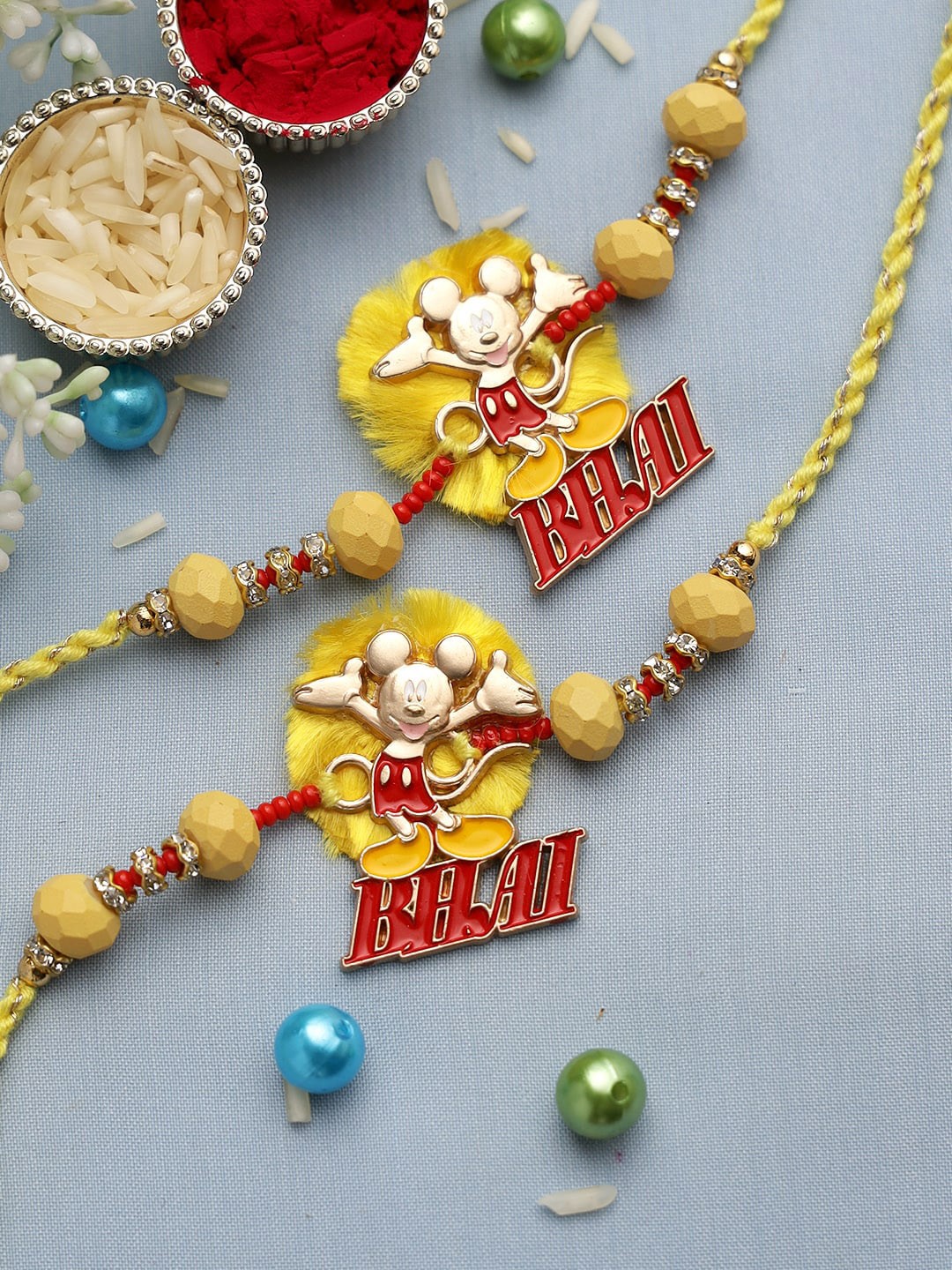 

Aapno Rajasthan Yellow & Red Set of 2 Mickey Mouse Rakhi with Roli Chawal & Card