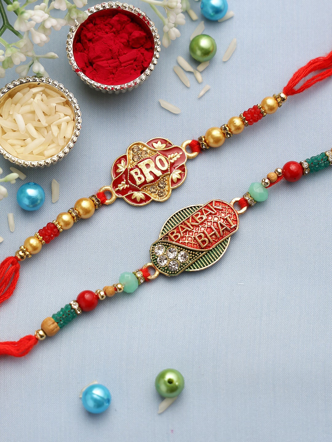 

Aapno Rajasthan Set Of 2 Red & Gold-Coloured Beaded Rakhi With Greeting Card, Multi