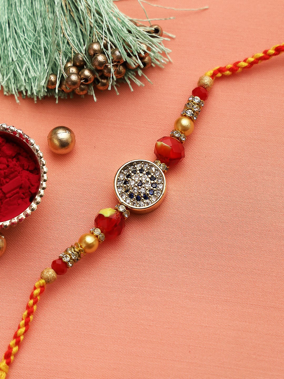 

Aapno Rajasthan Gold-Toned & Red Diamonds Beaded Embellished Rakhi