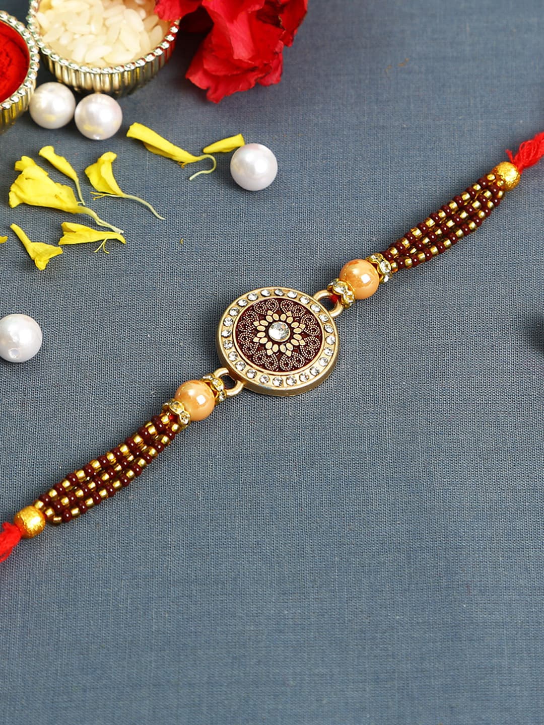 

Aapno Rajasthan Gold-Toned & Red Filigree Work Jewelled Rakhi
