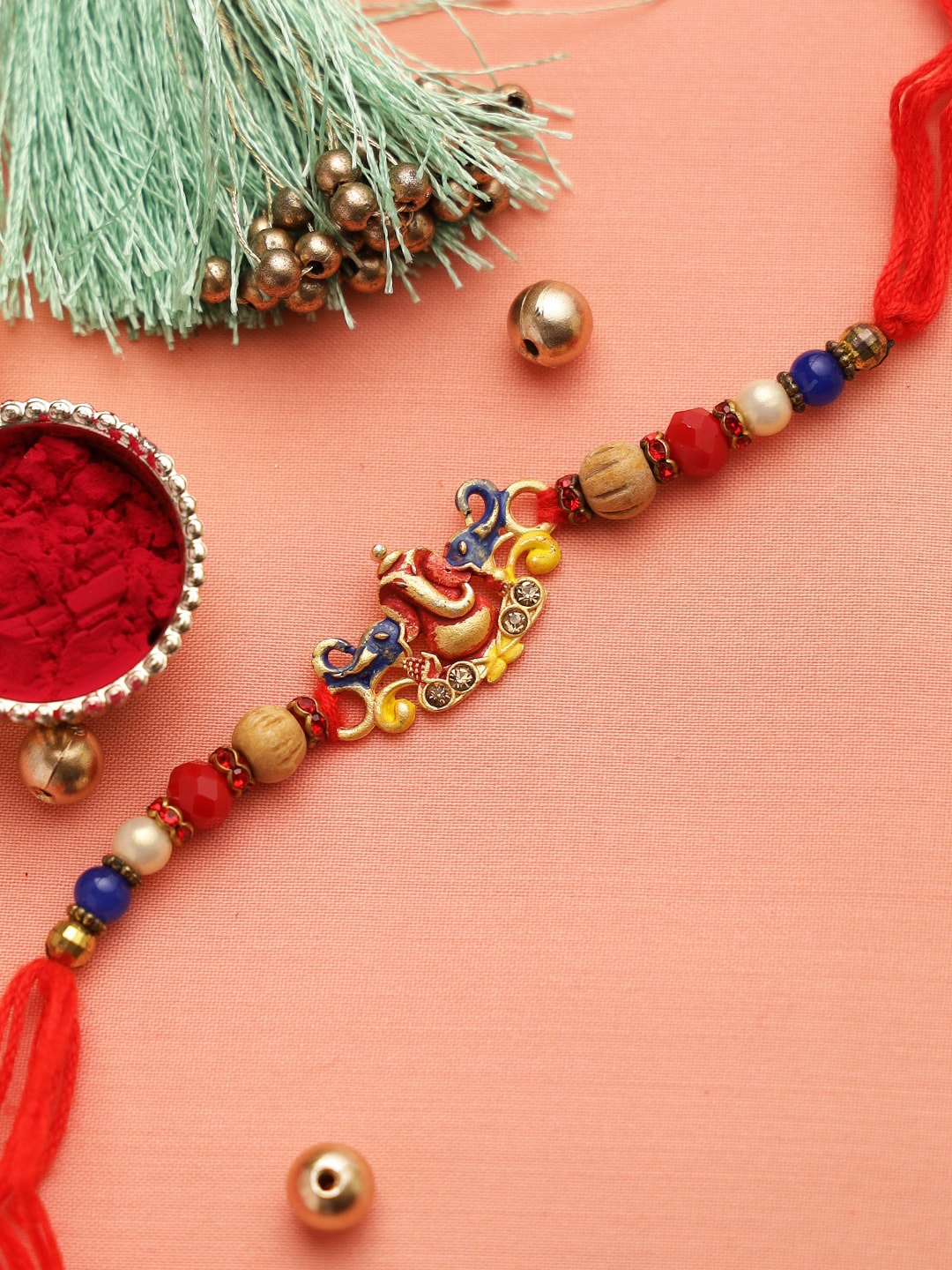 

Aapno Rajasthan Gold-Toned & Red Lord Ganapati Motif Beaded Rakhi