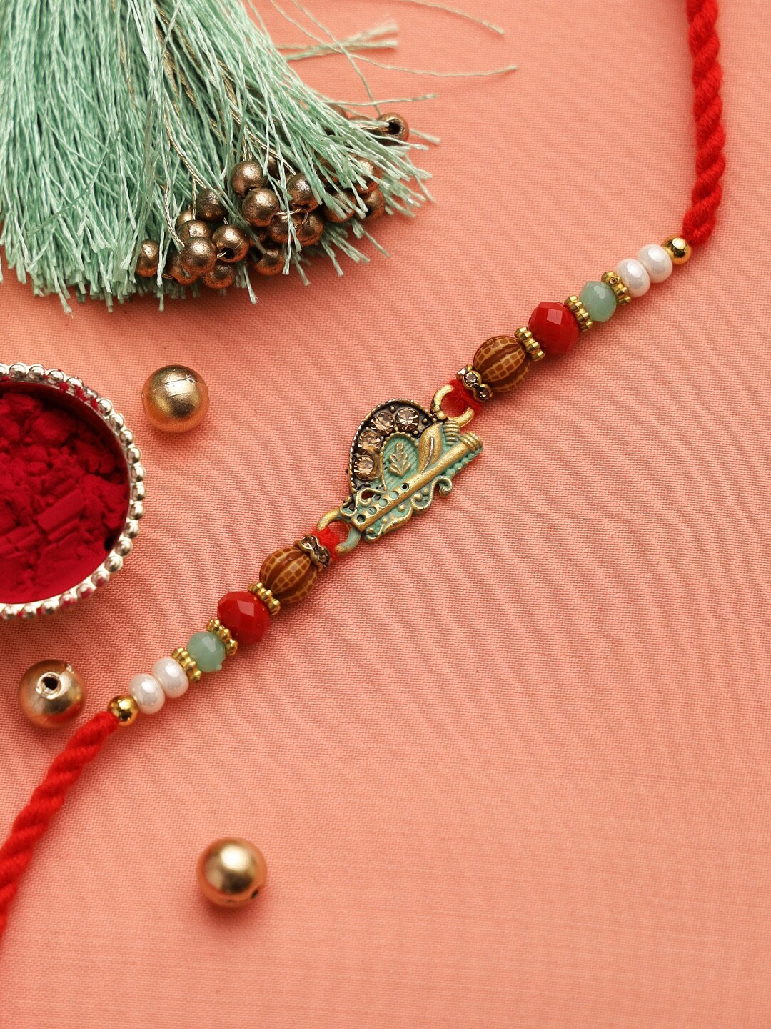 

Aapno Rajasthan Red & Sea Green Krishna Motif Rakhi with Roli Chawal & Card