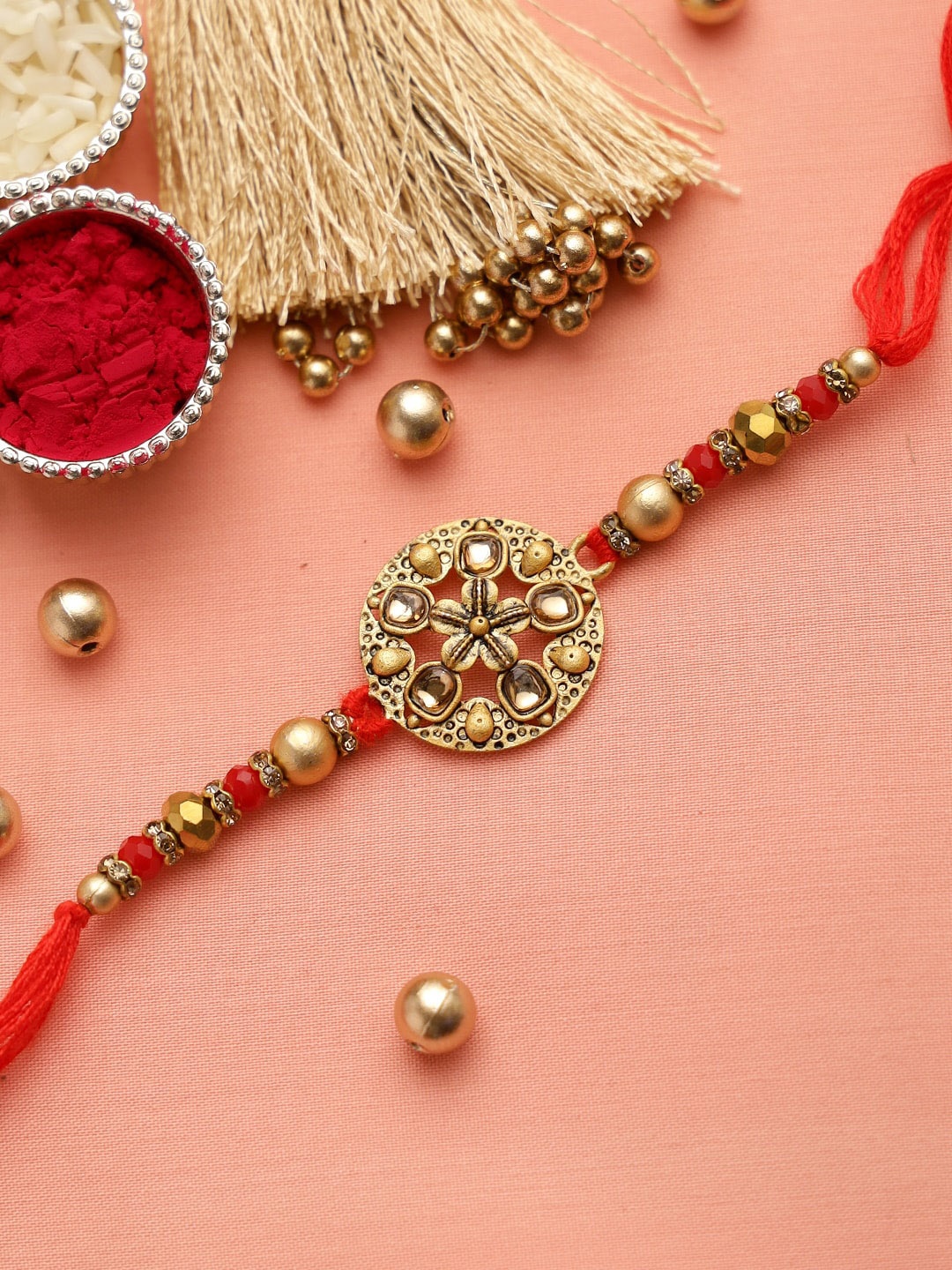 

Aapno Rajasthan Red & Gold-Toned Stone-Studded & Beaded Rakhi