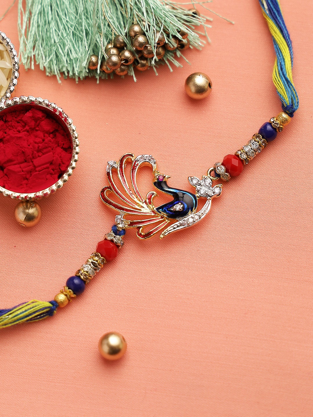 

Aapno Rajasthan Blue & Red American Diamonds Peacock Motif Rakhi with Circular Beads