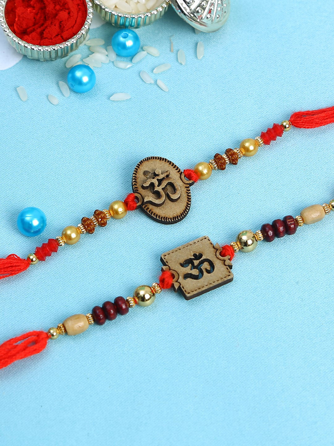 

Aapno Rajasthan Set of 2 Brown & Red Wooden Om Rakhi with Roli Chawal & Card