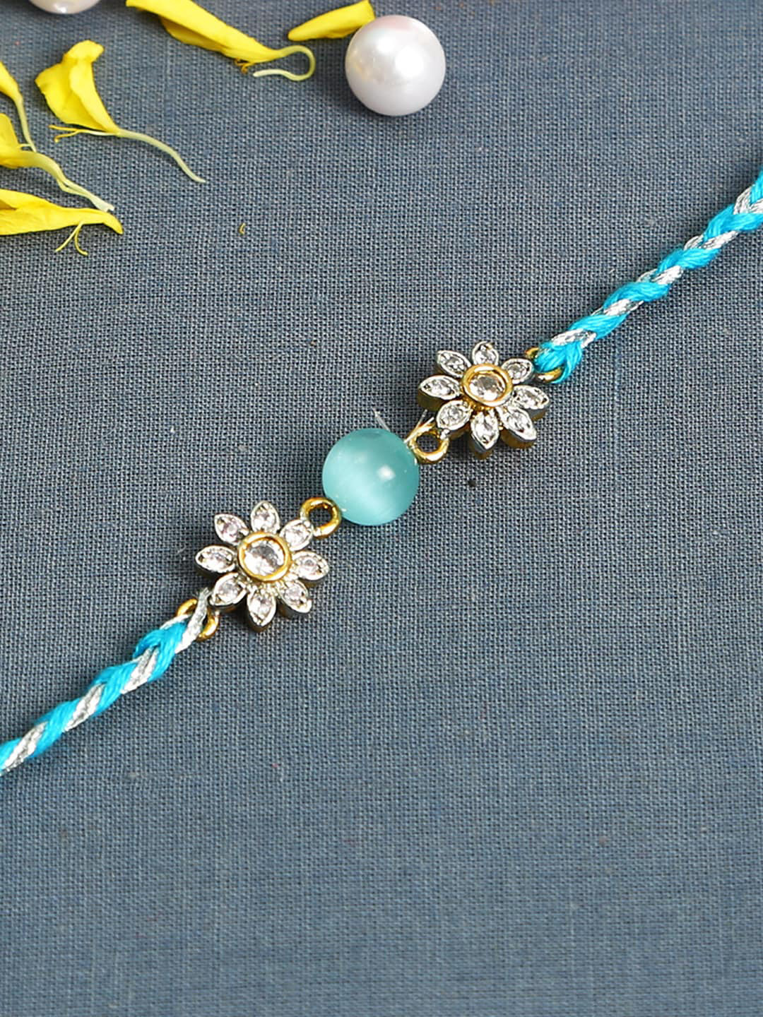 

Aapno Rajasthan Turquoise Blue Floral AD Studded Rakhi with Roli Chawal & Card