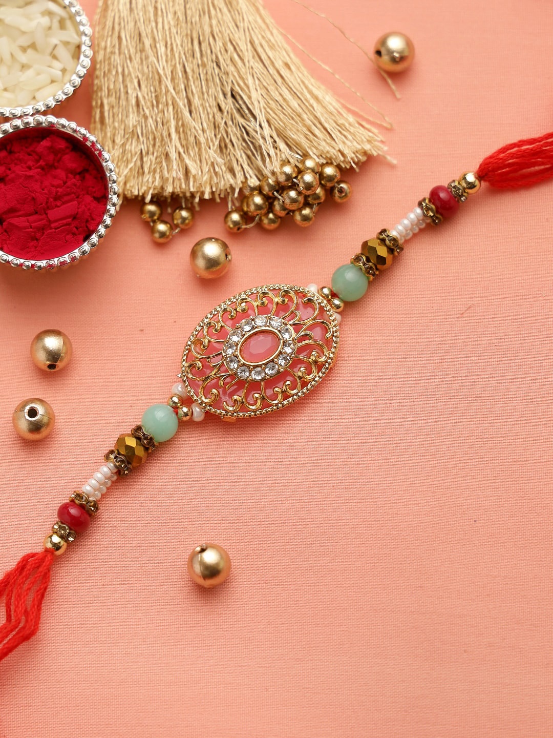 

Aapno Rajasthan Pink Golden Filigree Work Studded Thread Rakhi