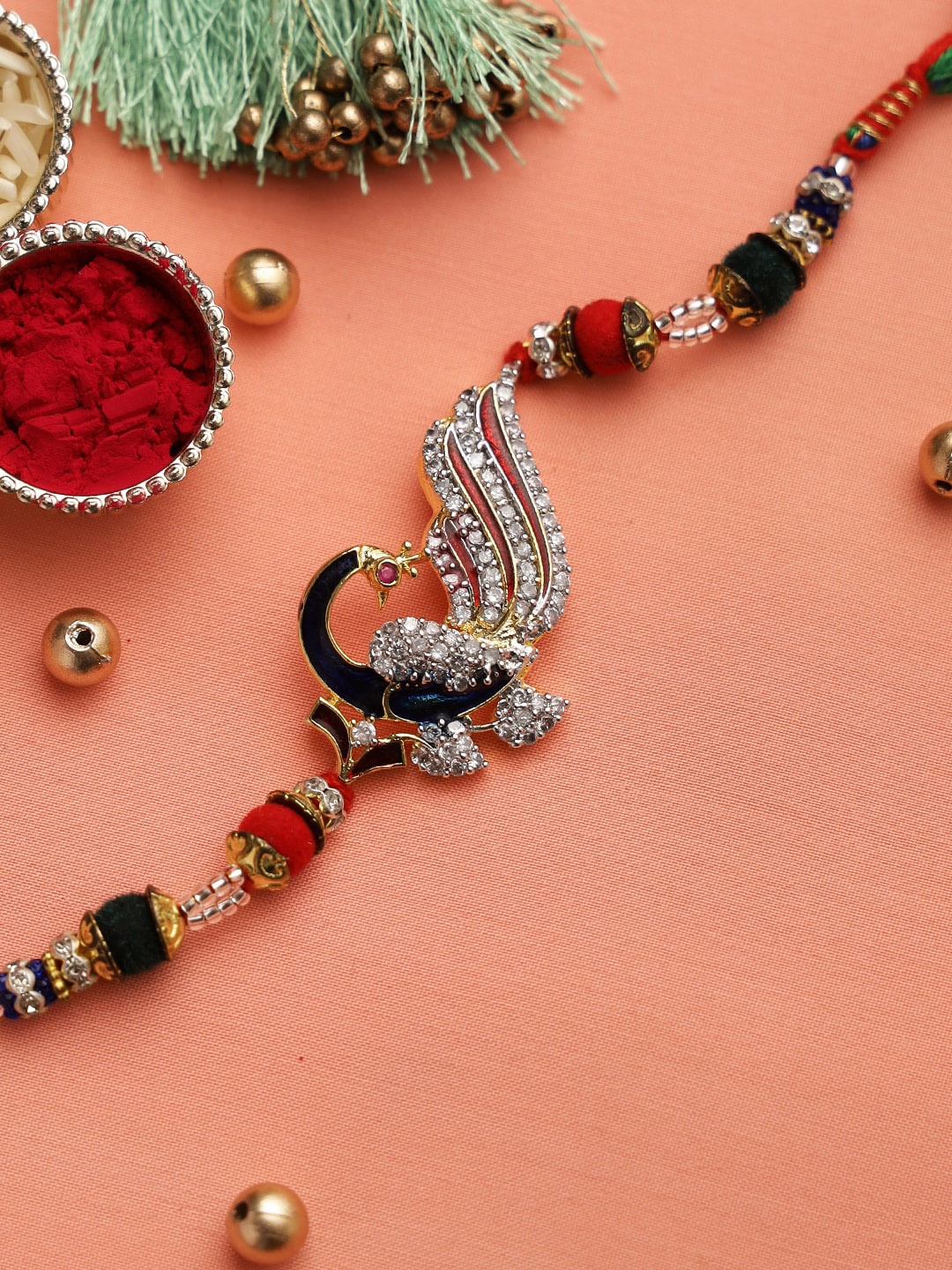 

Aapno Rajasthan Blue & Red Beautifully Jewelled Peacock Motif Rakhi