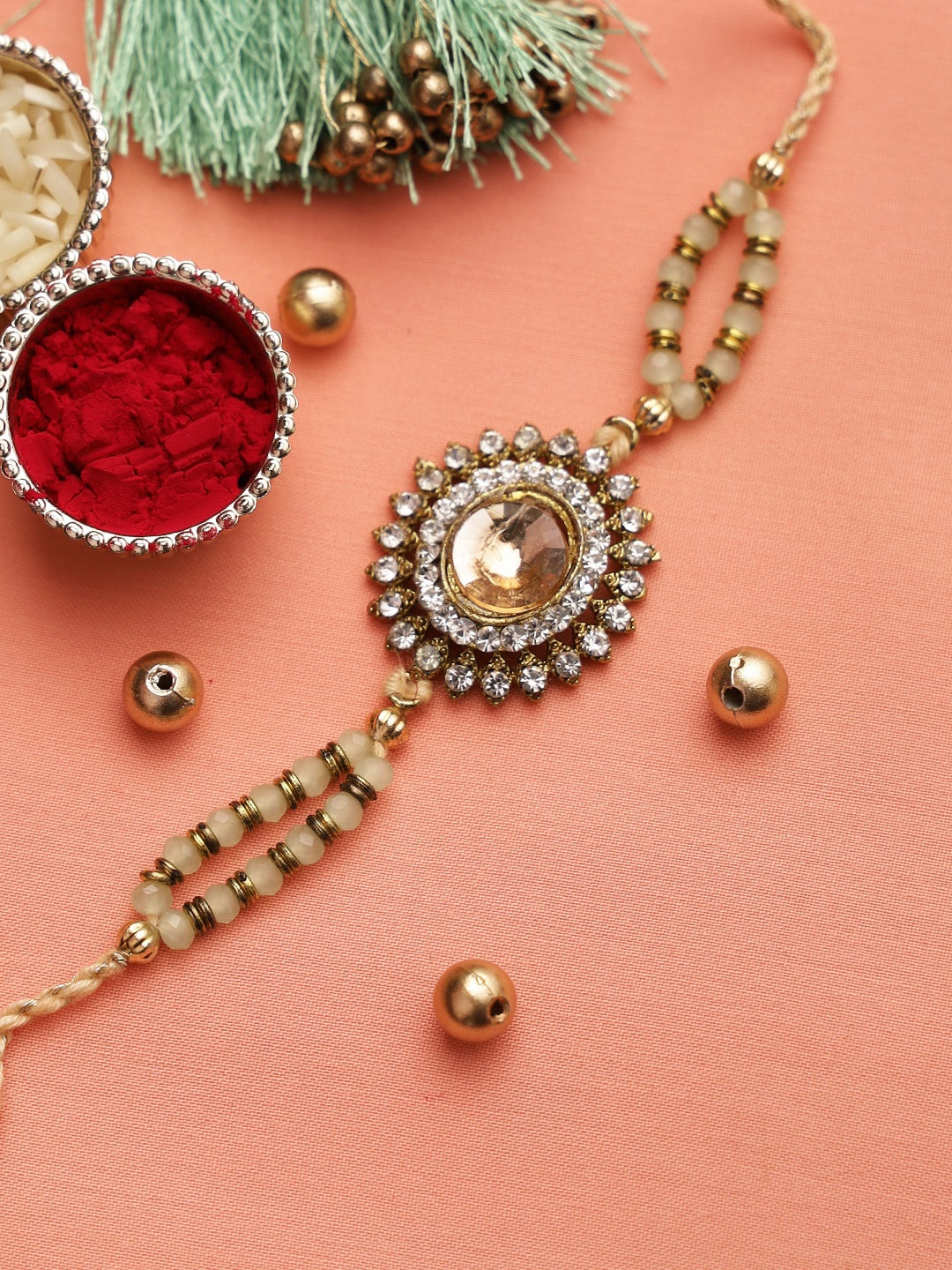 

Aapno Rajasthan Beige Kundan Beaded Circular Thread Rakhi
