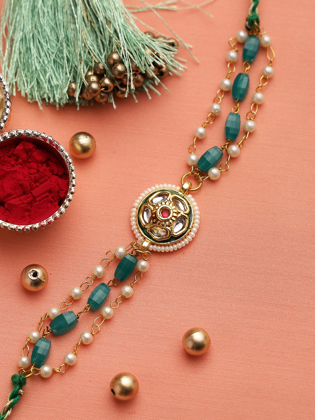 

Aapno Rajasthan Gold-Toned & Green Pearl and Garnate Beads Kundan Rakhi Set