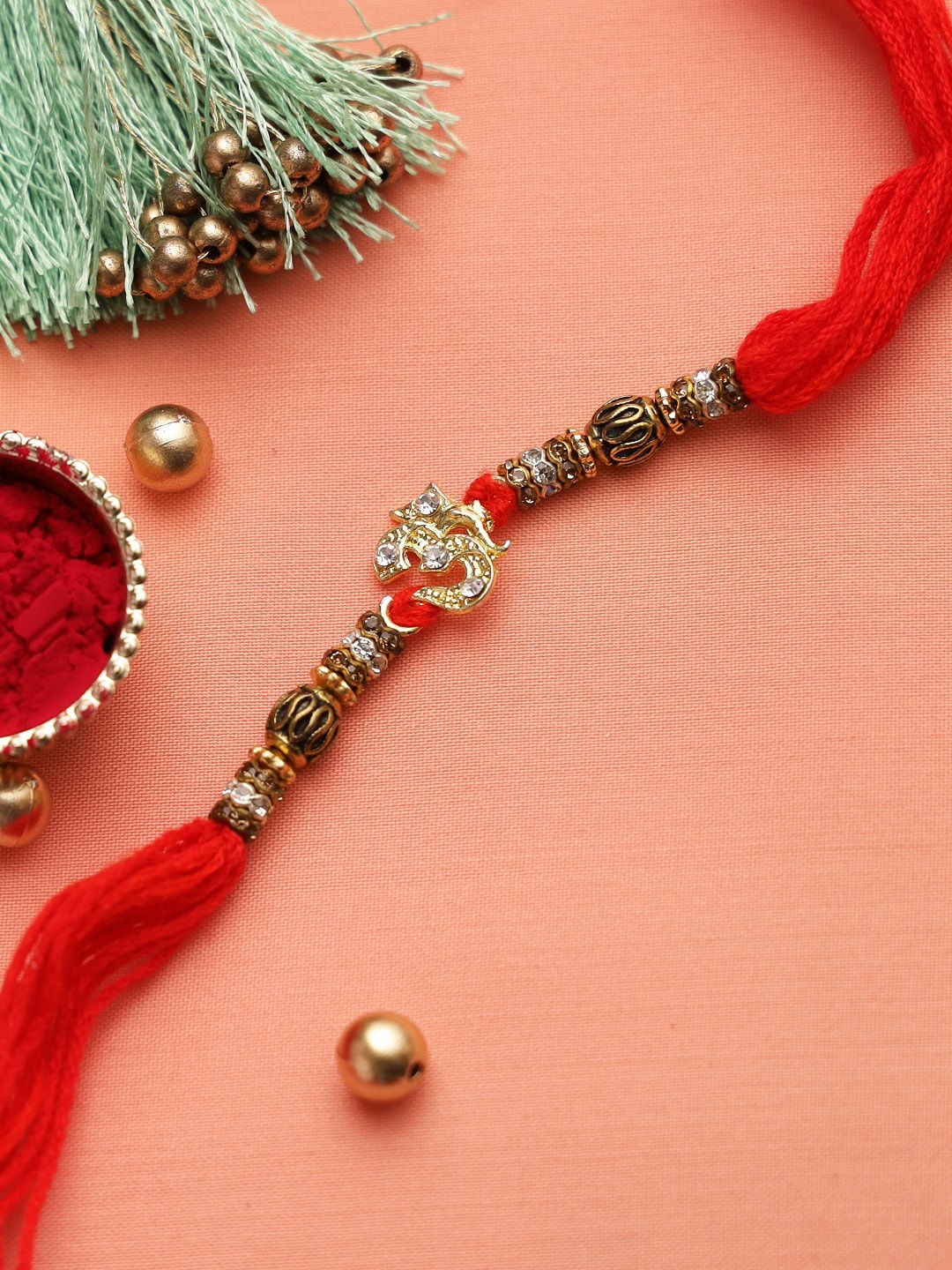 

Aapno Rajasthan Gold Toned & Red OM Studded Thread Rakhi