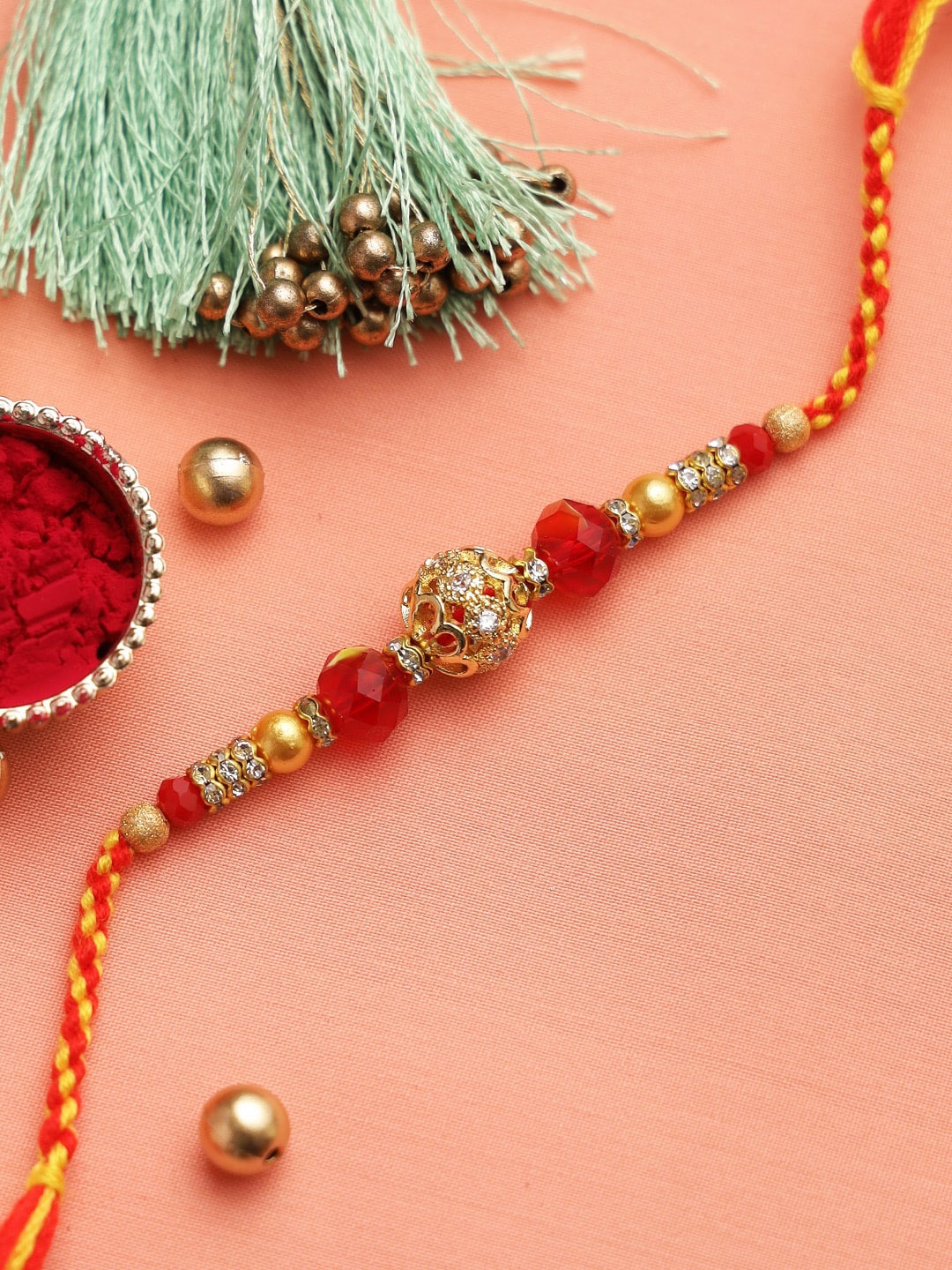 

Aapno Rajasthan Gold-Toned & Red Beaded Rakhi with Roli Chawal & Card
