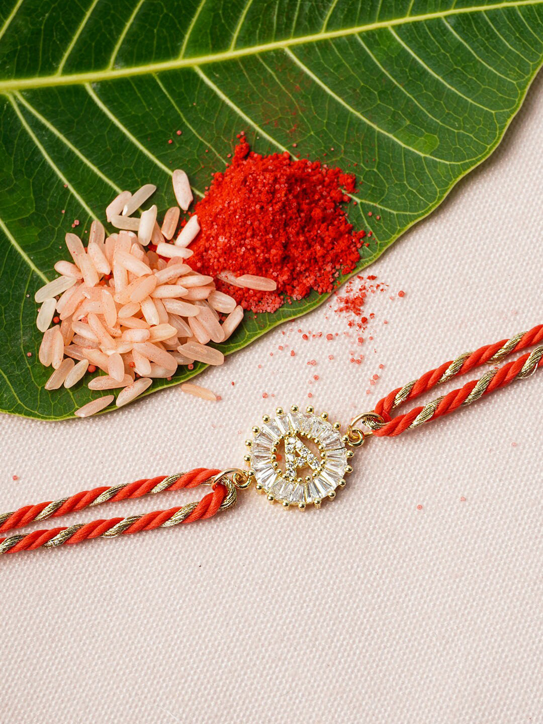 

Ferosh Gold-Toned & Red A-Alphabet Rhinestone Rakhi