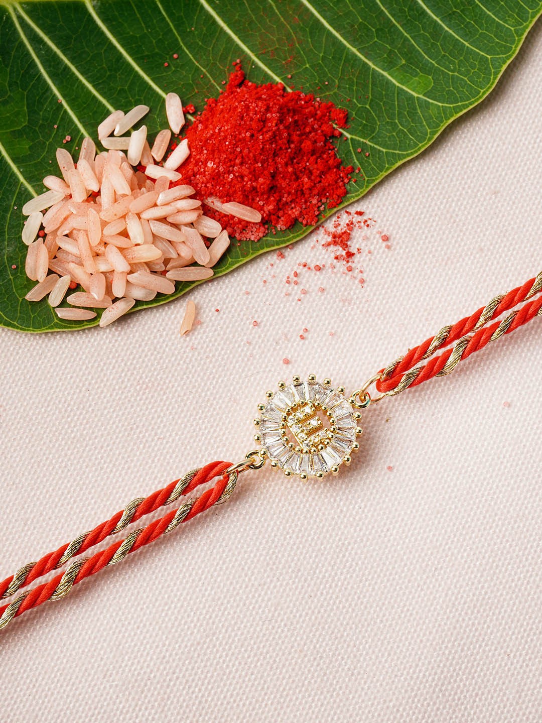 

Ferosh Red & Gold-Toned 'E' Alphabet Rhinestone Studded Rakhi with Roli Chawal