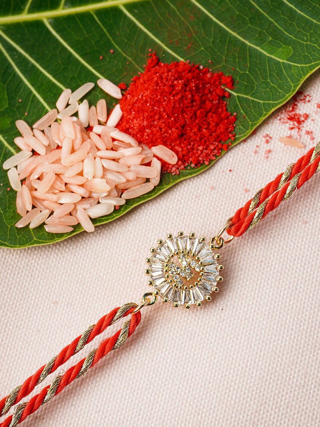 

Ferosh Adults-Unisex Gold & Red Alphabet M Rhinestone Rakhi With Roli Chawal