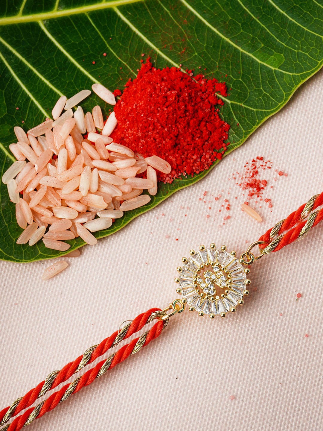 

Ferosh Gold-Toned & Red W Alphabet Rhinestone Rakhi With Roli Chawal