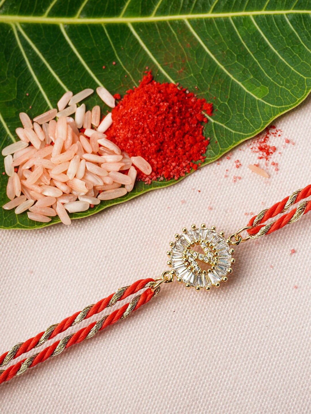 

Ferosh Gold Toned & Red N alphabet Studded Thread Rakhi