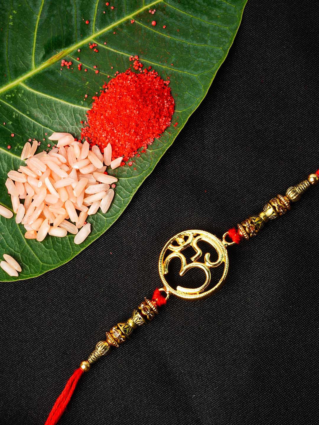 

Urmika Gold Toned Om Pendant Rakhi With Roli Chawal