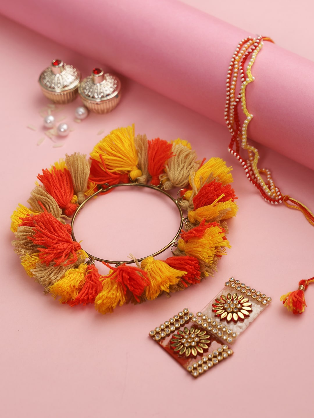 

Aapno Rajasthan Set Of 2 Red & Yellow Stone-Studded & Pom Pom Charm Rakhi & Lumba With Roli Rice & Greeting Card