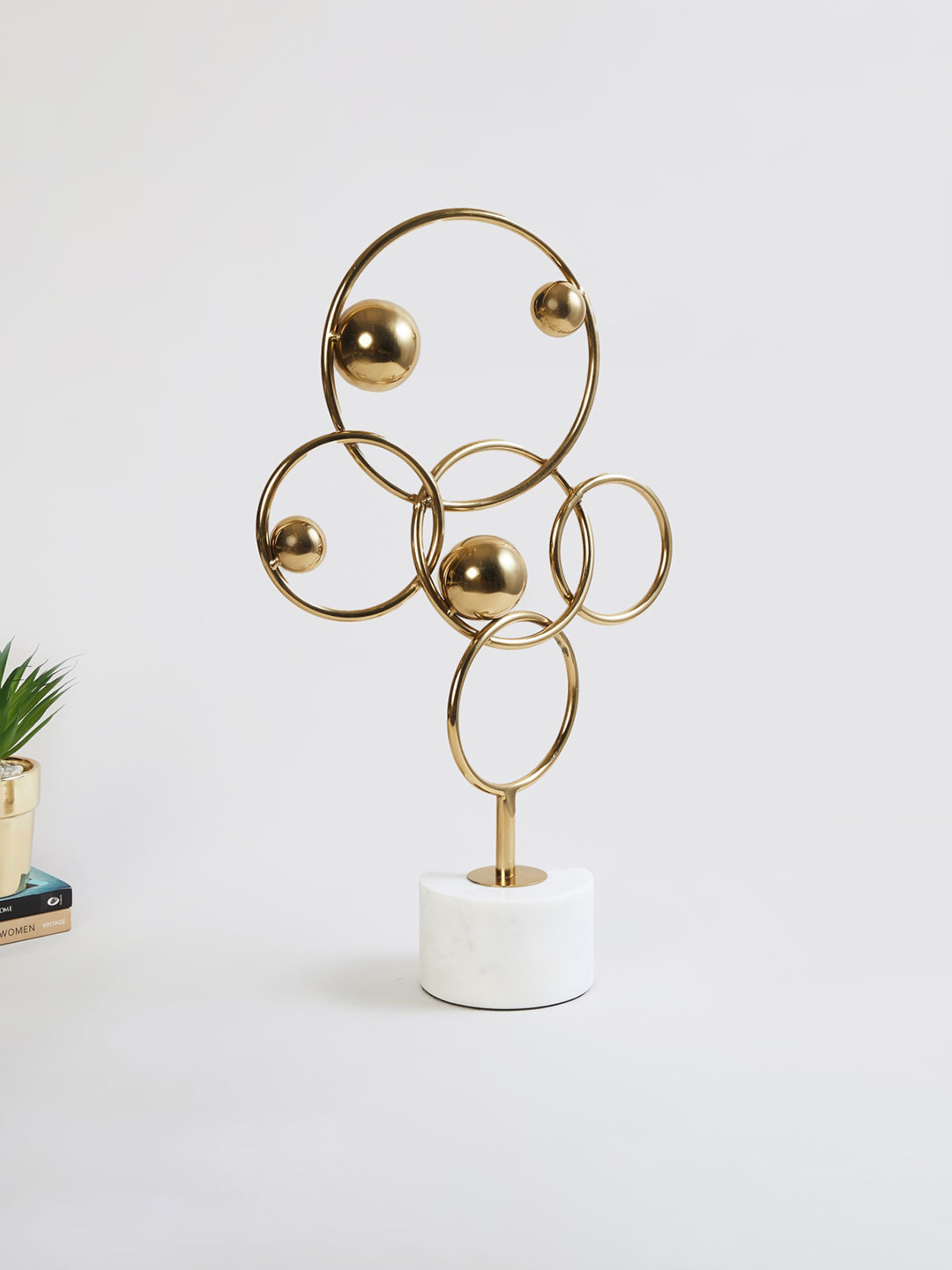 

Home Centre Gold-Toned & White Solid Ring Metal Table DecorShowpiece