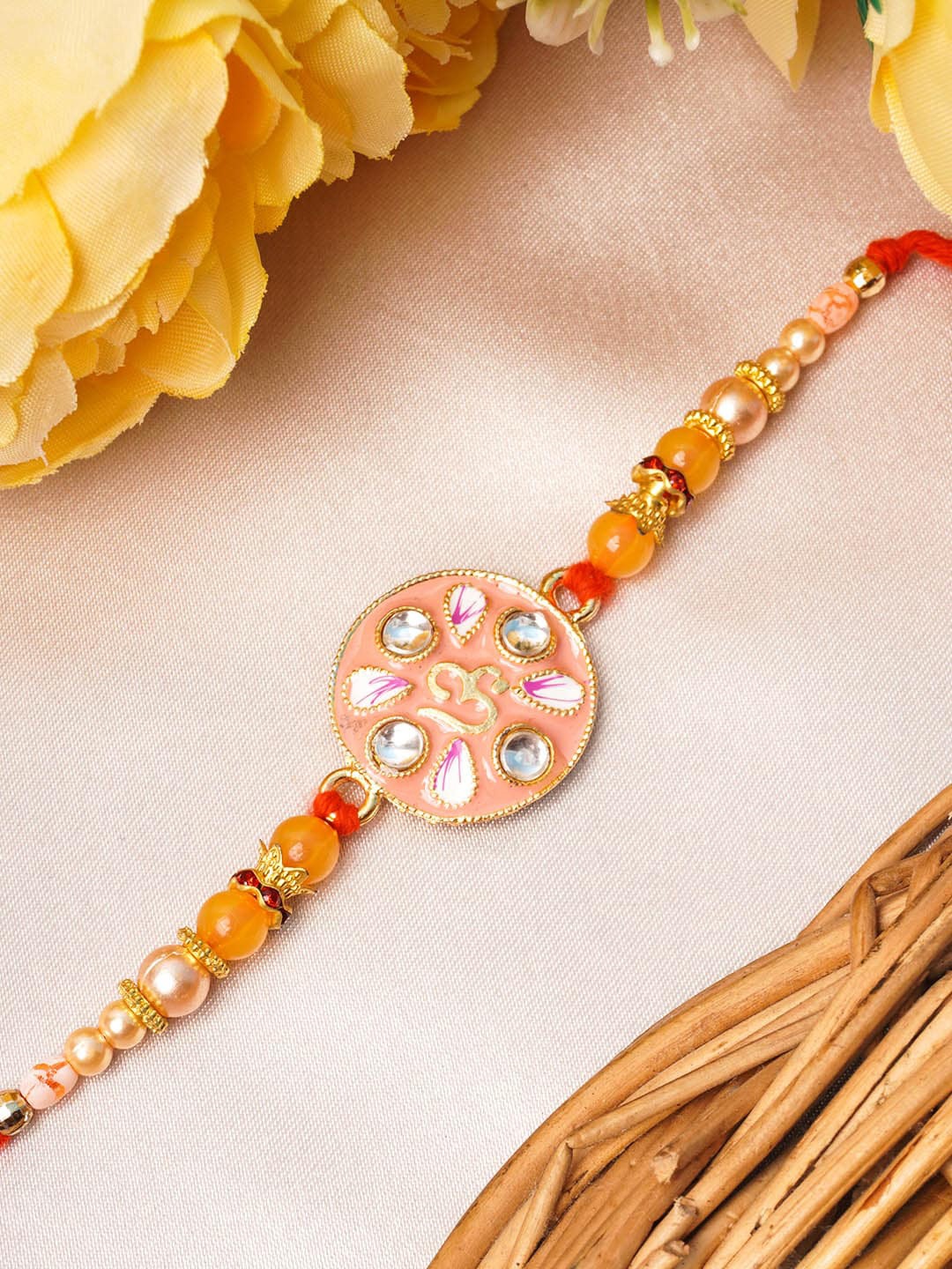 

Urmika Meenakari Gold Toned & Peach Rakhi with Roli & Chawal