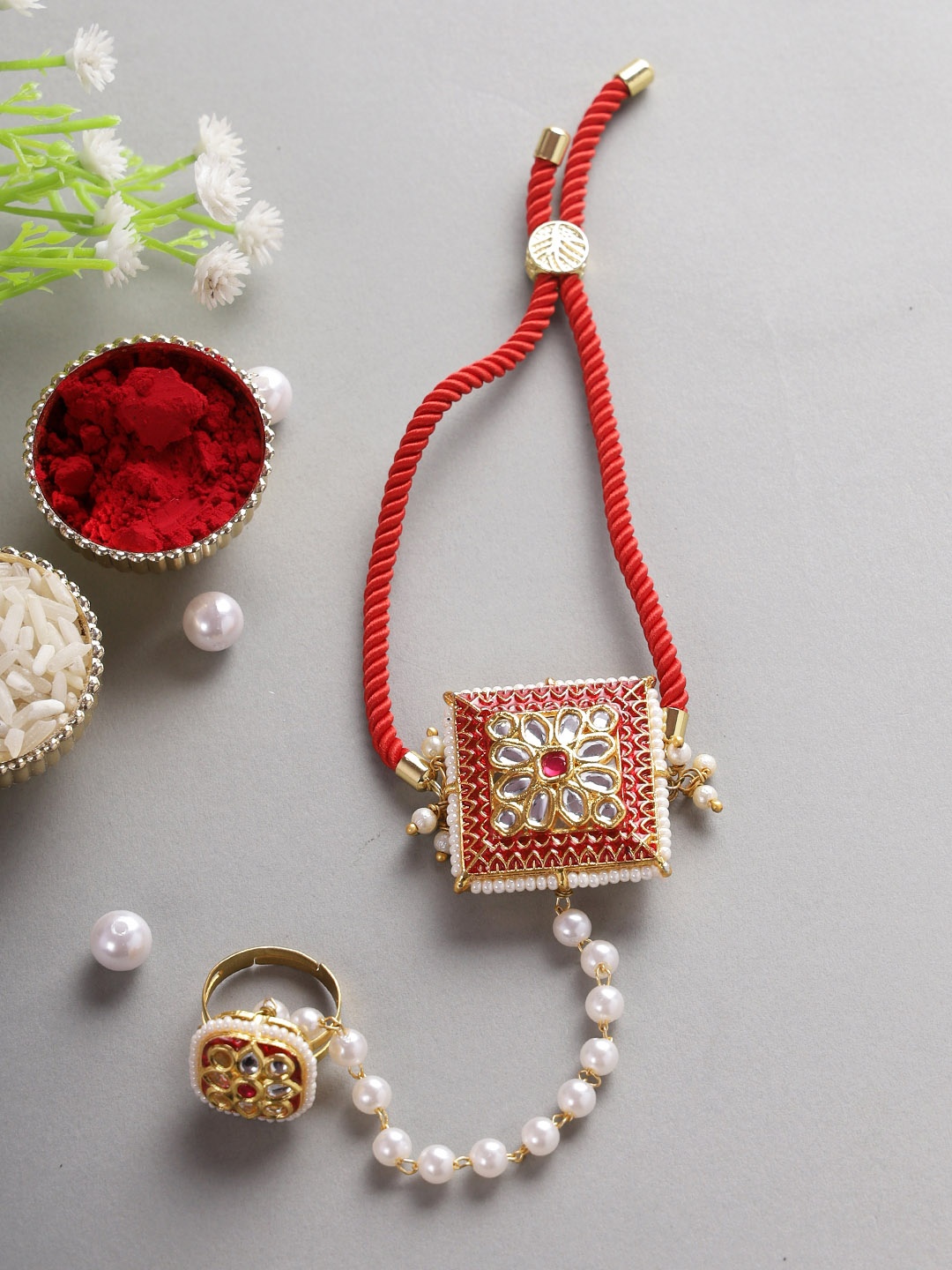 

Aapno Rajasthan Women Gold Toned & Red Stone Studded & Beaded Hathphool Rakhi