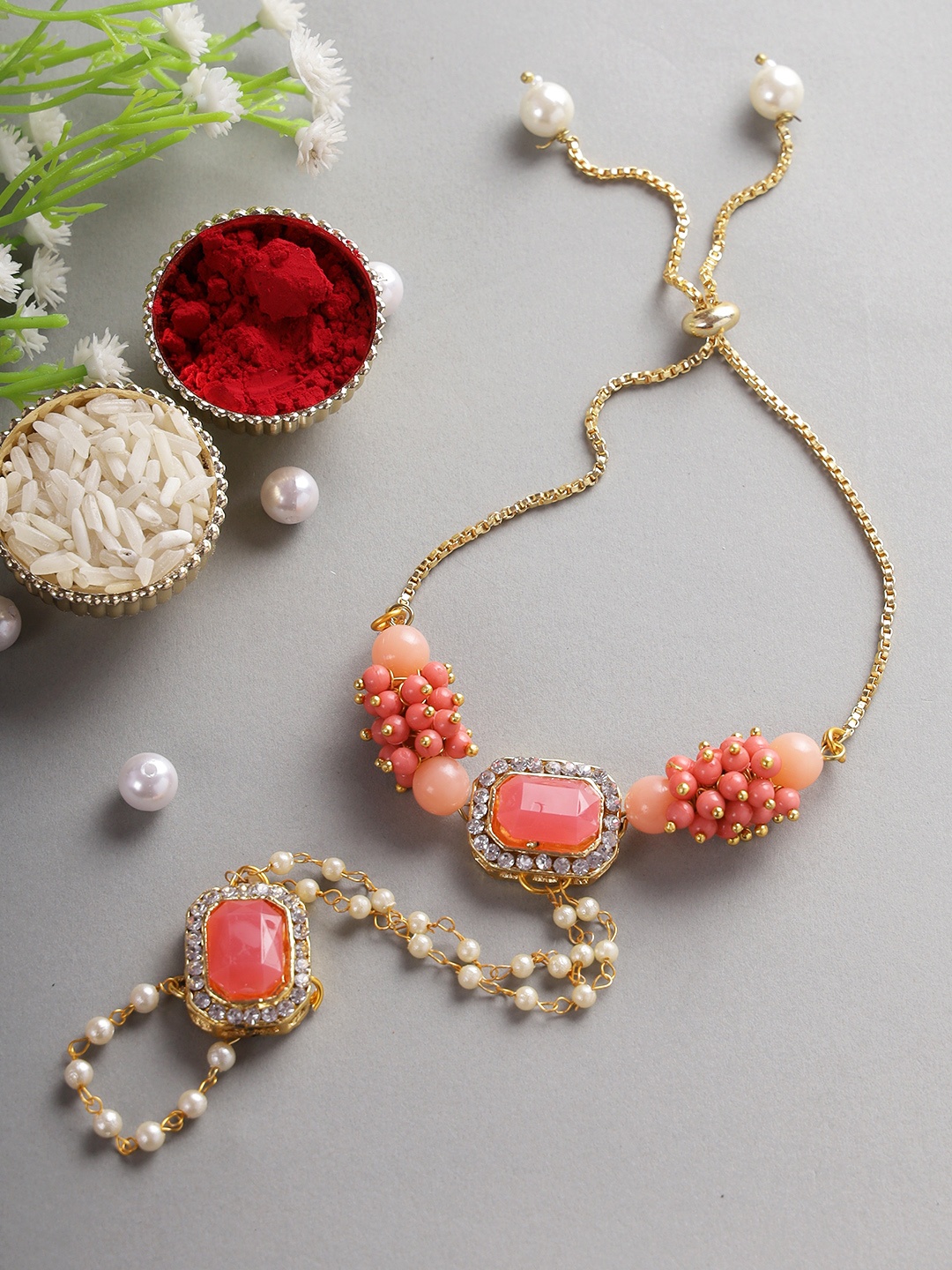 

Aapno Rajasthan Red & Gold-Toned American Diamonds and Stone Stud Hathphool Rakhi