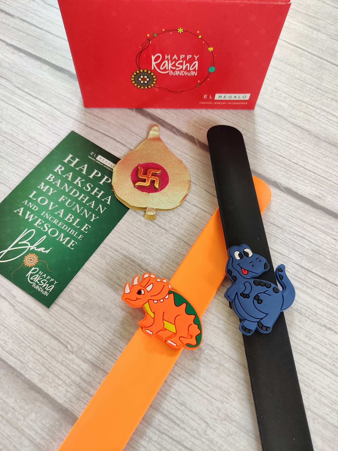 

EL REGALO Kids Set of 2 Orange Black Rakhi Combo with card & Roli Chawal