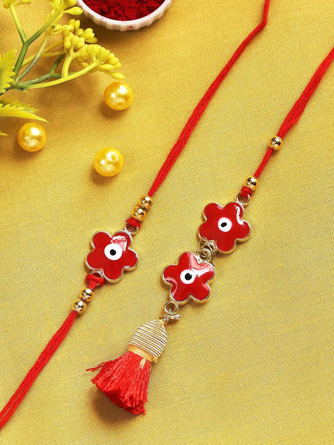 

Aapno Rajasthan Set Of 2 Red & White Evil Eye Flower Rakhi Set with Box