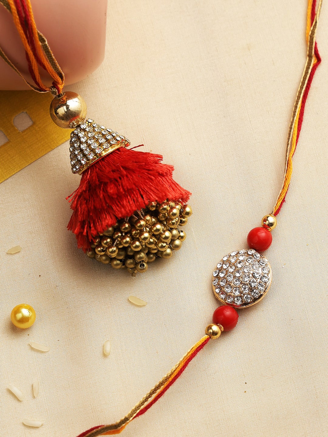 

Aapno Rajasthan Set of 2 Gold-Toned & Red Stone Studded & Beaded Ethnic & Fancy Bhaiya Bhabhi Rakhi Set with Box