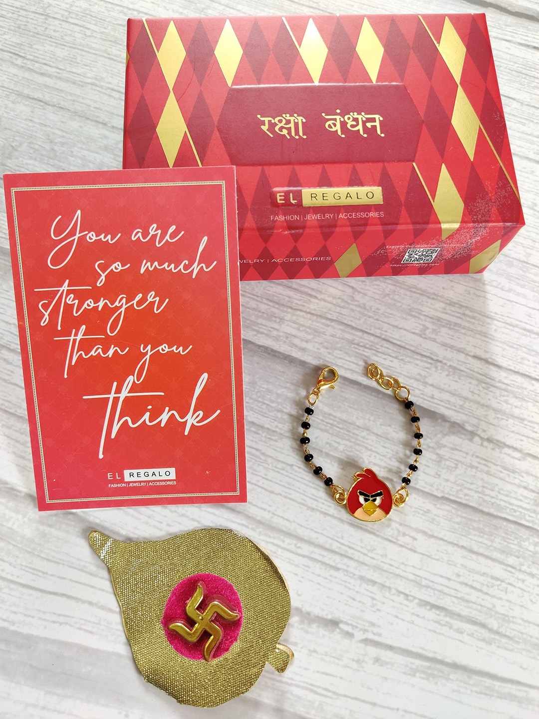 

EL REGALO Baby Red Nazaria Rakhi Combo With Greeting Card & Roli Chawal Shagun