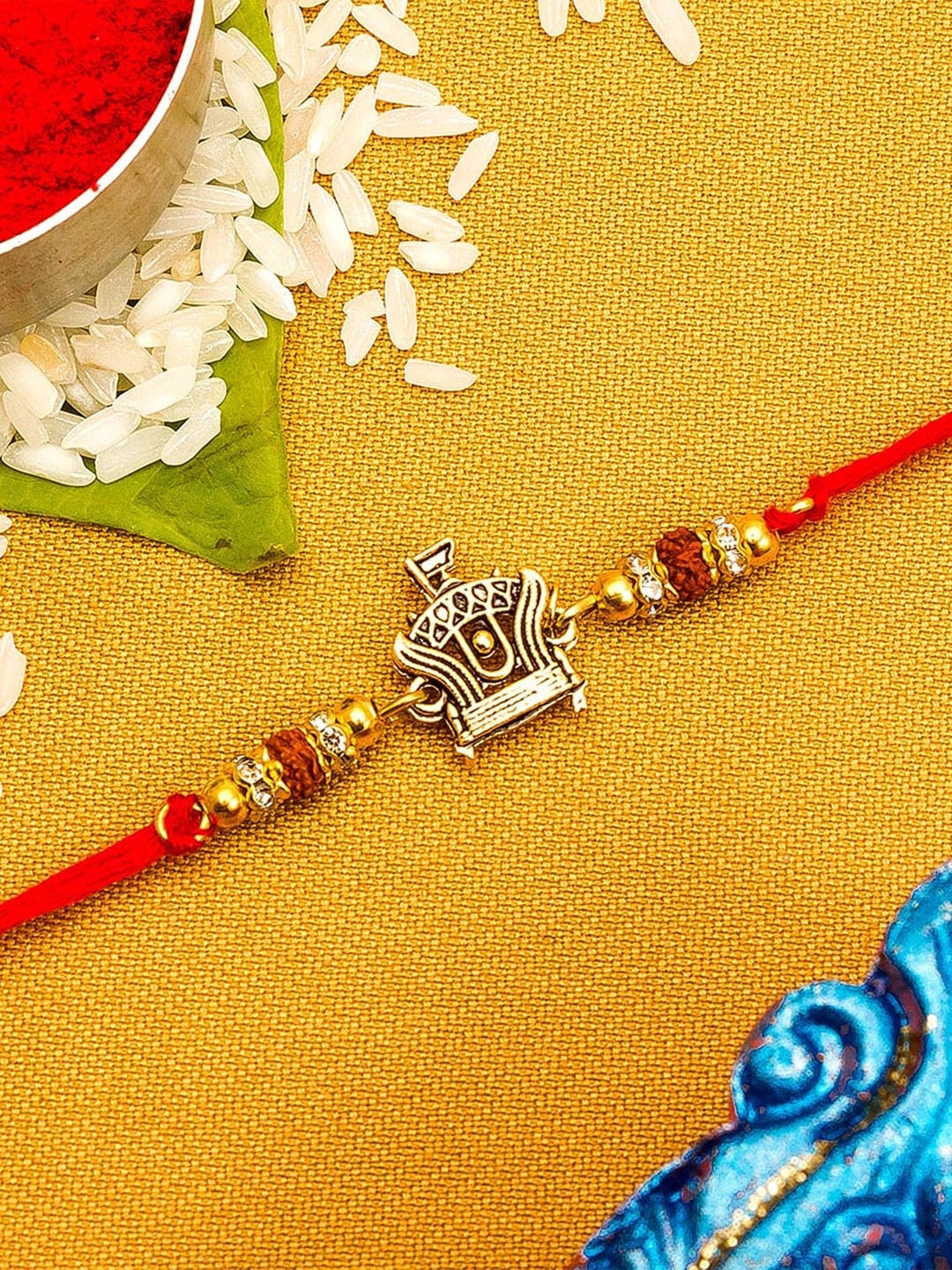 

aadita Gold Toned & Red String Rakhi with Roli Chawal
