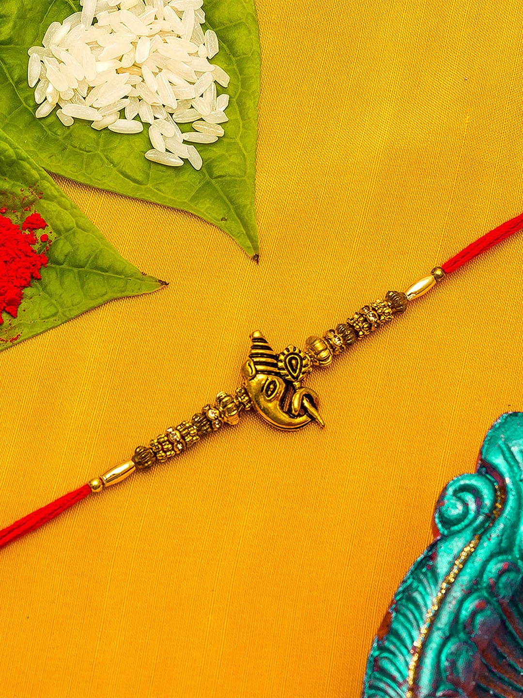 

aadita Gold-Toned & Red Thread Rakhi With Roli Chawal