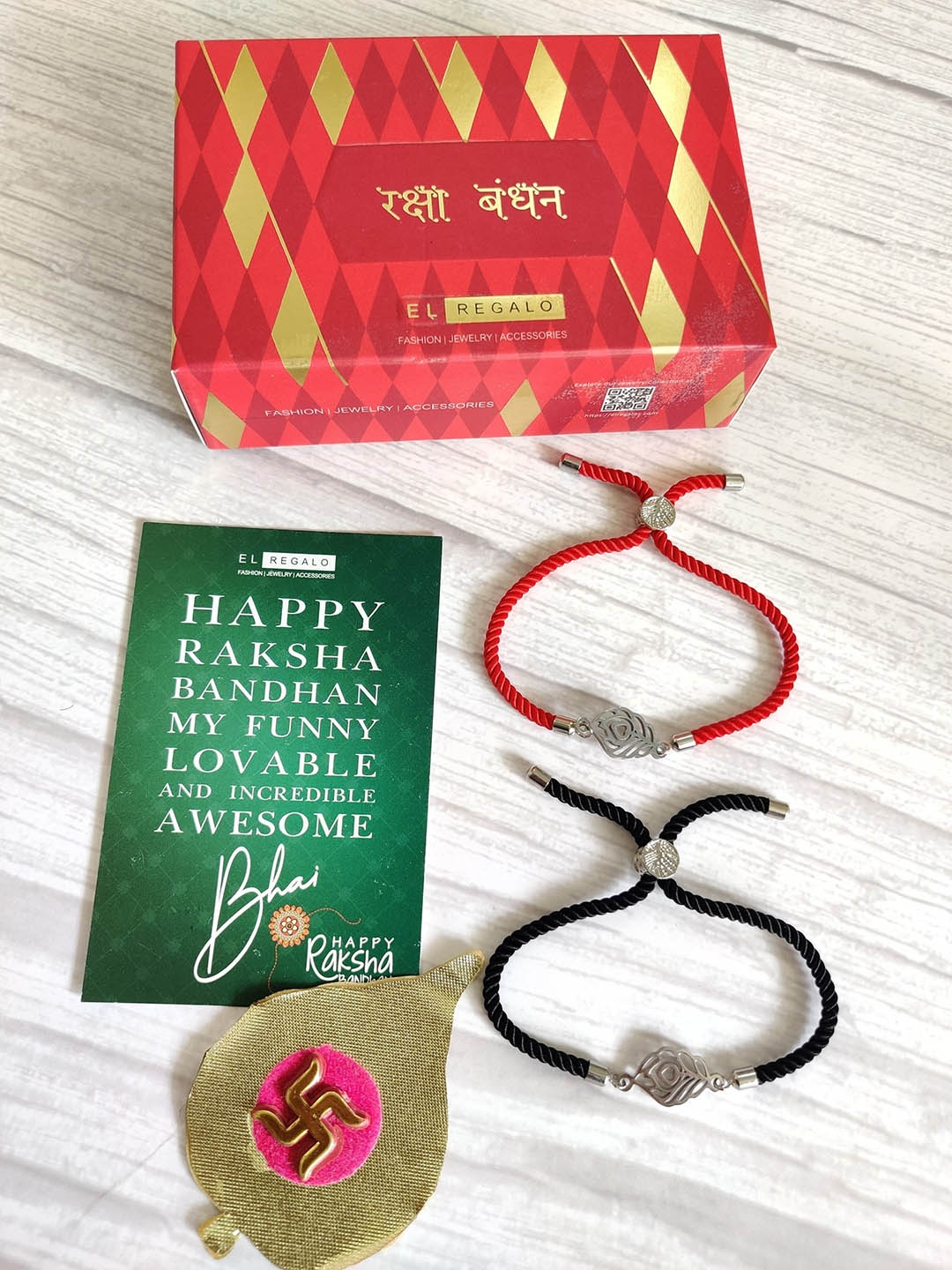 

EL REGALO Set Of 2 Silver Coloured, Red & Black Evil Eye Wrap Around Rakhi With Roli Chawal & Raksha Bandhan Greeting Card