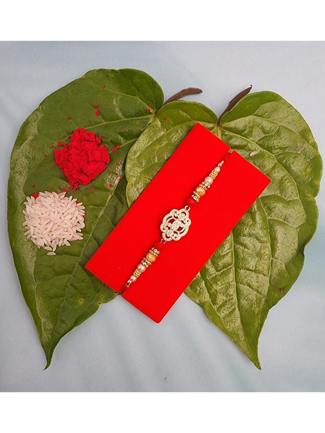 

YOUSTYLO Stone Studded Rakhi With Roli, Chawal & Greeting Card, Red