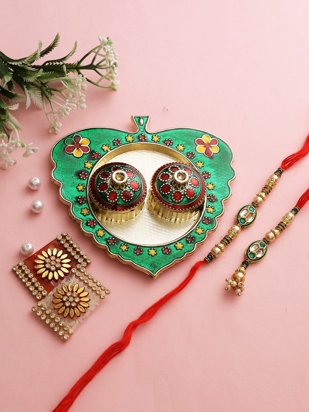 

Aapno Rajasthan Green & Red Beaded Rakhi with Paan Leaf-Shaped Roli Chawal Thali